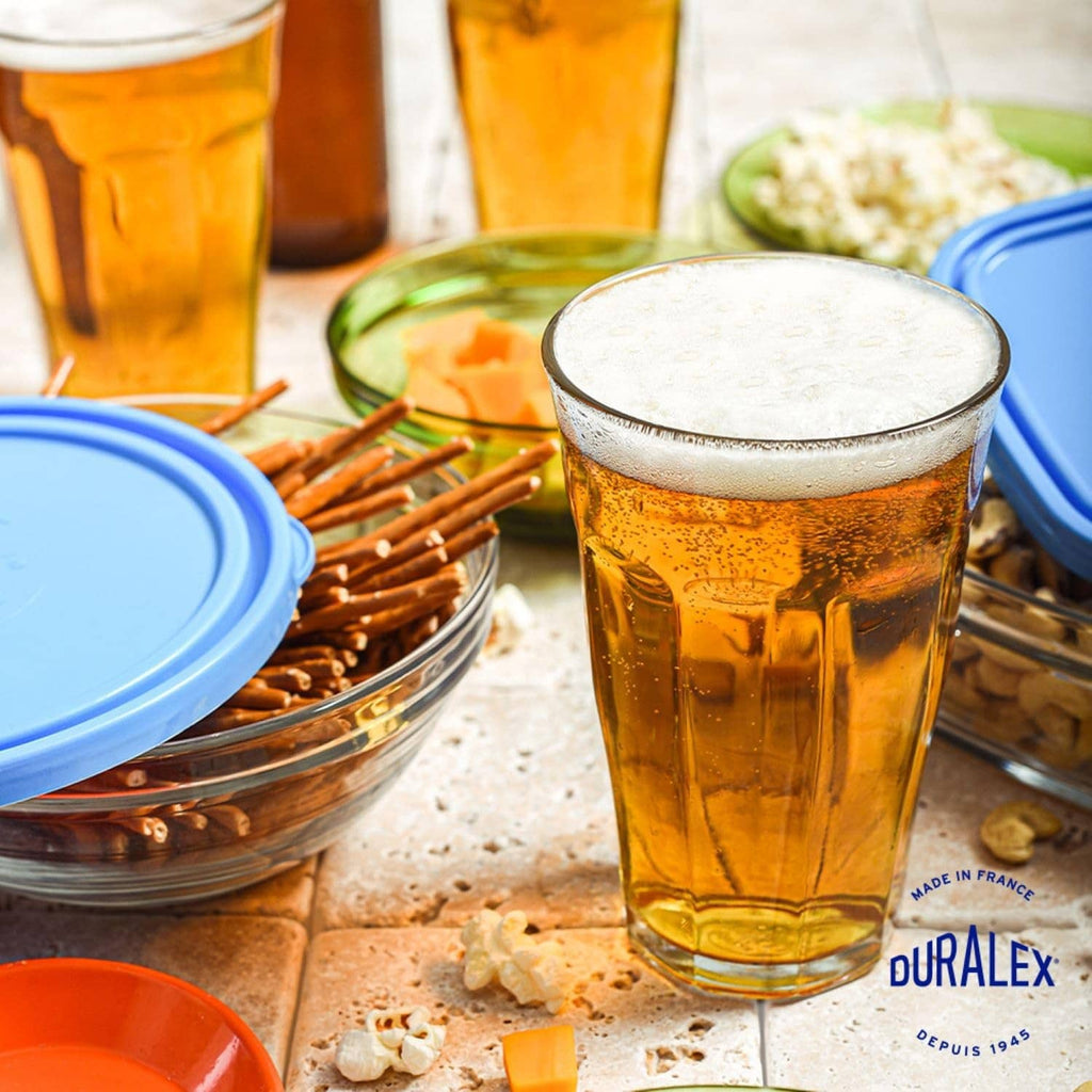 Clear glass tumbler with amber beer and frothy top