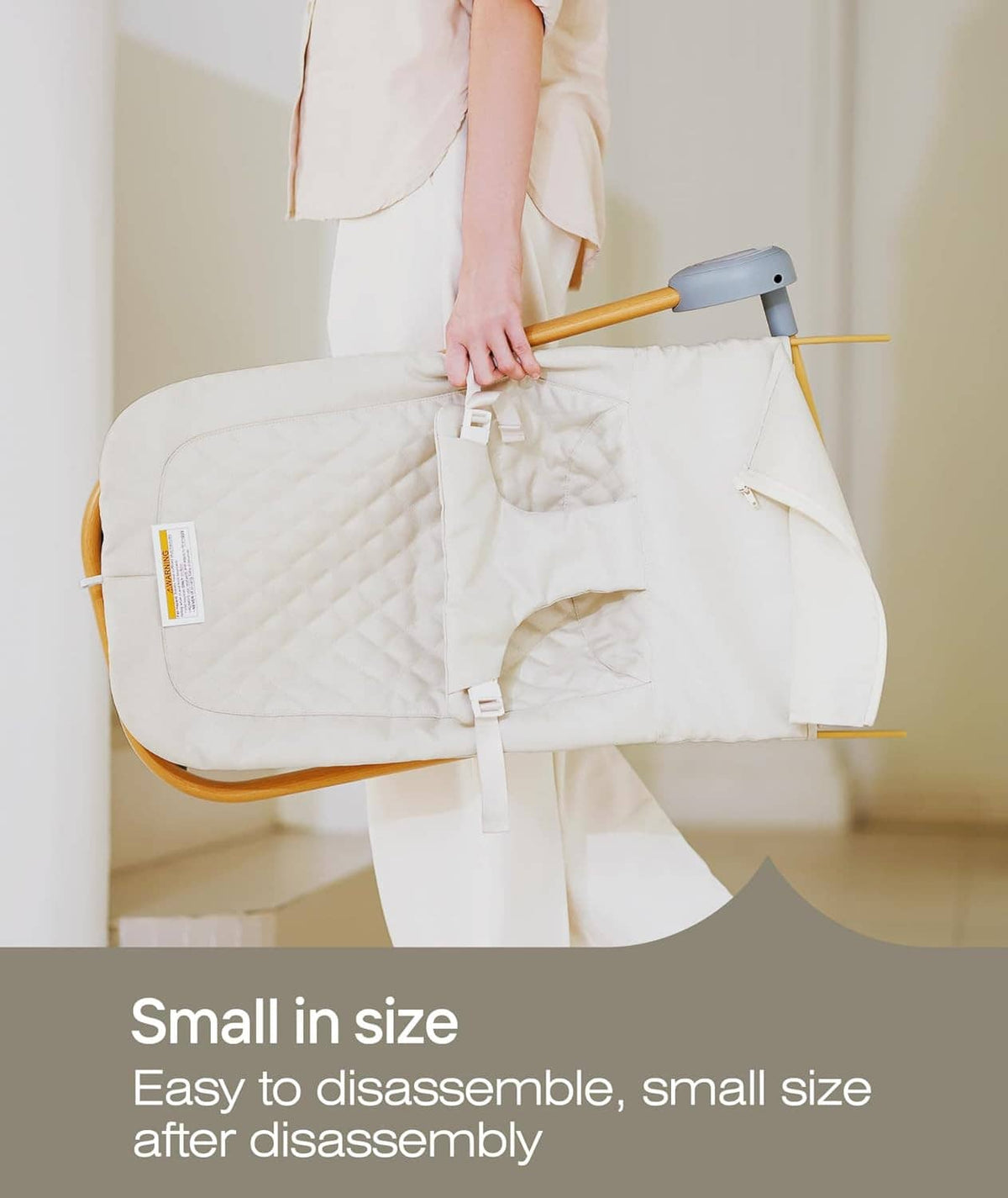 Baby bouncer seat being held for disassembly, showing compact folded frame