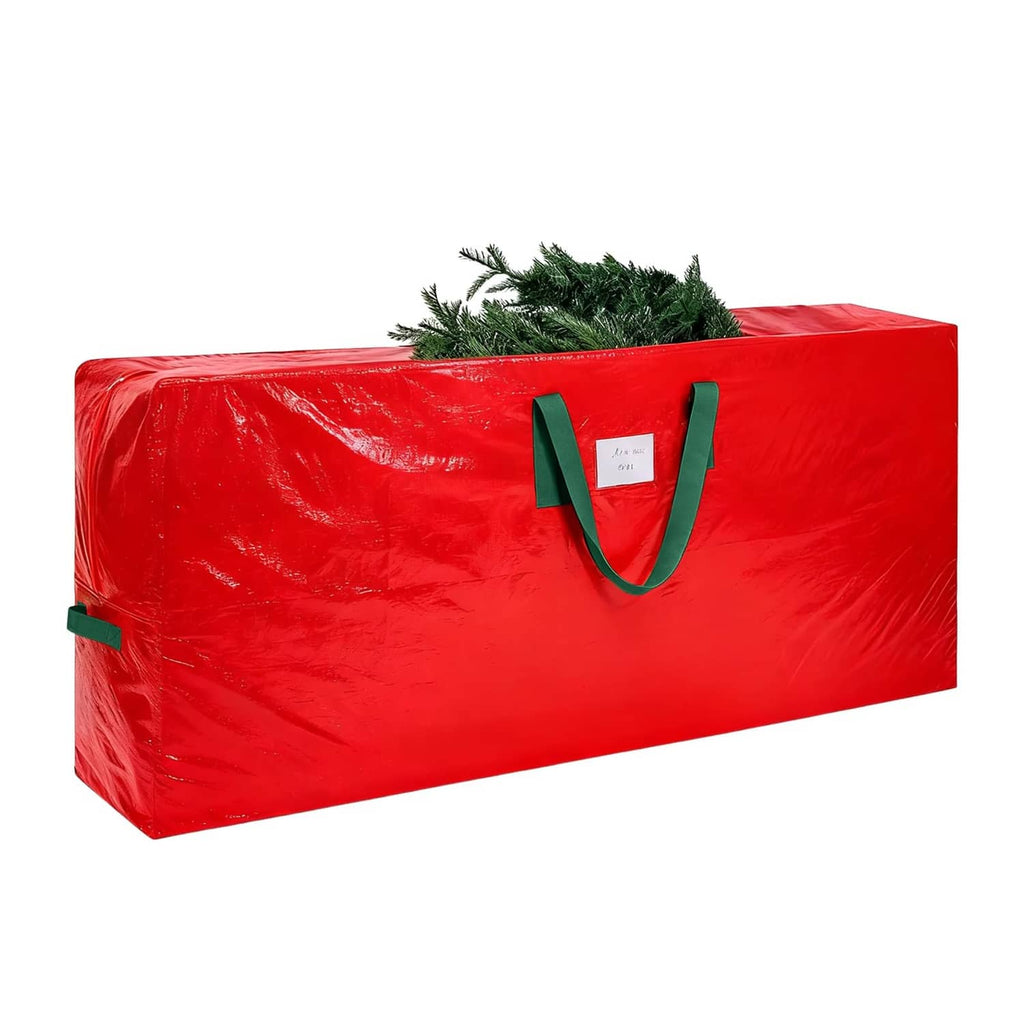 Red Christmas tree storage bag with green handles and evergreen branches peeking out
