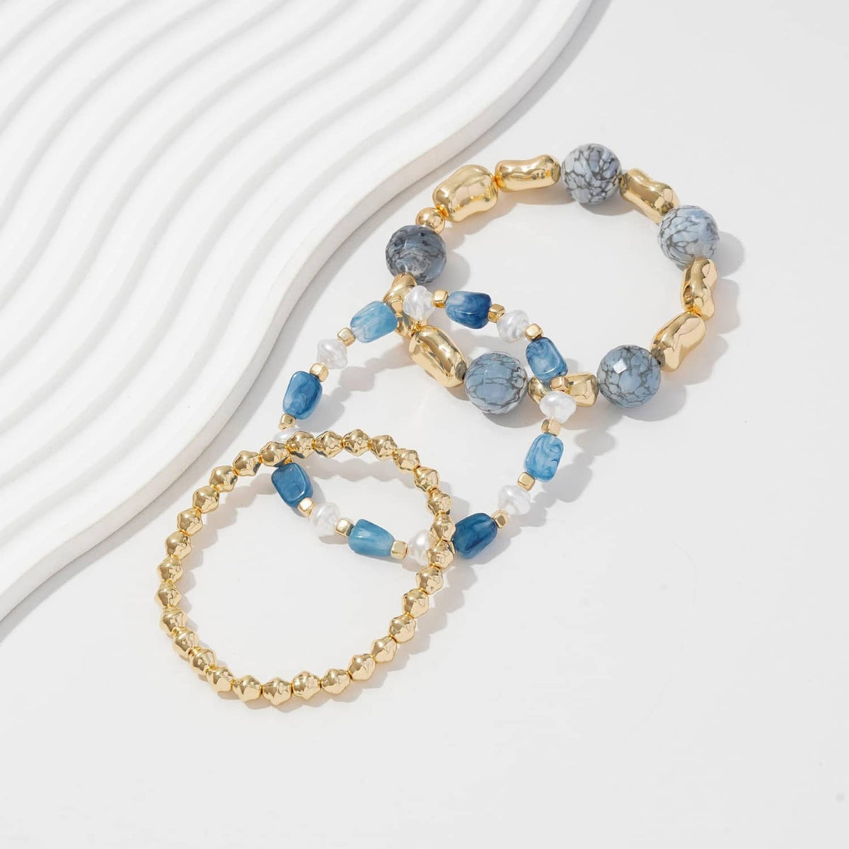 Blue and gold beaded stretch bracelets set with round gold links and stone beads
