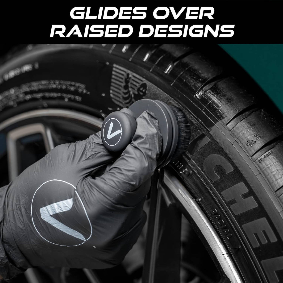 Black tire shine applicator brush in gloved hands for dressing a vehicle tire sidewall