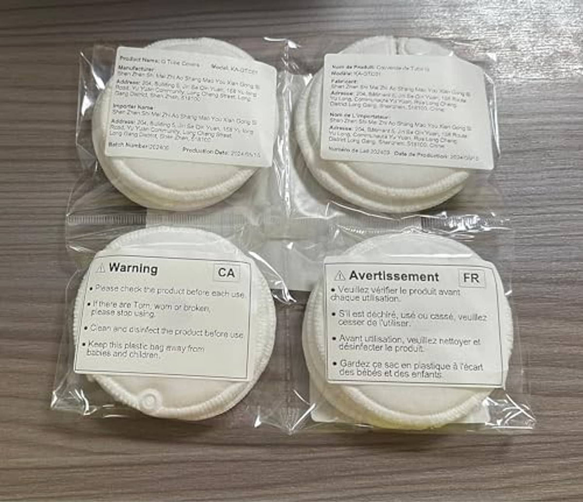 Sealed bag with four white round button cover pads, labels on top