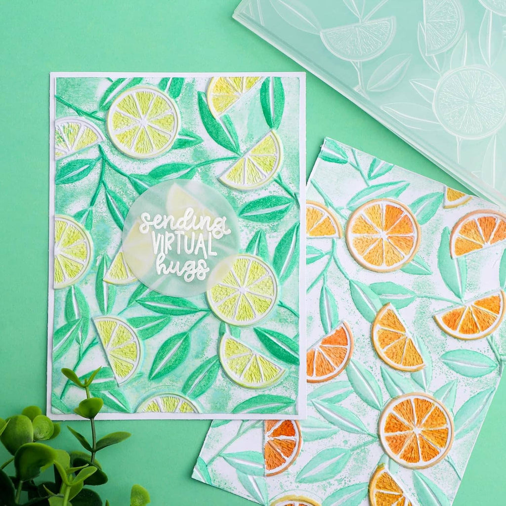 Two embossed citrus pattern cards on teal background, lemon slice and leaf design