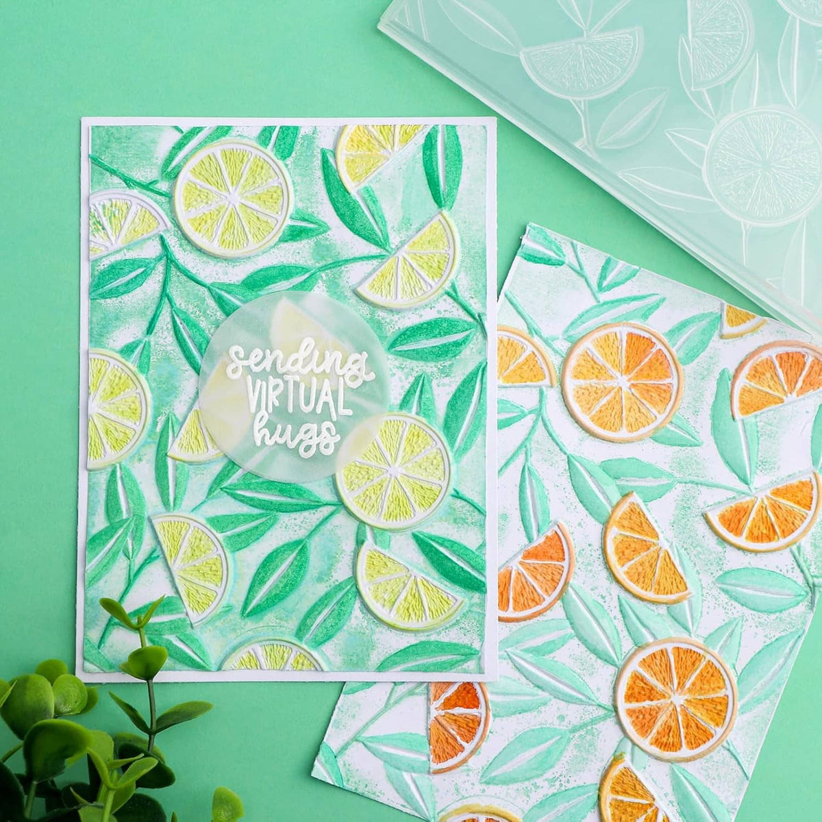 Two embossed citrus pattern cards on teal background, lemon slice and leaf design