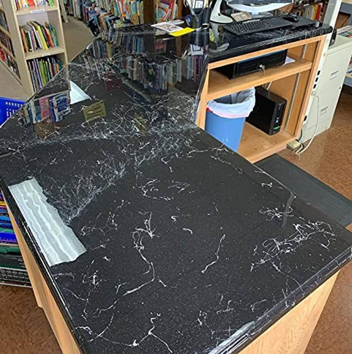 Large black epoxy-coated countertop with white vein-like patterns and sheen