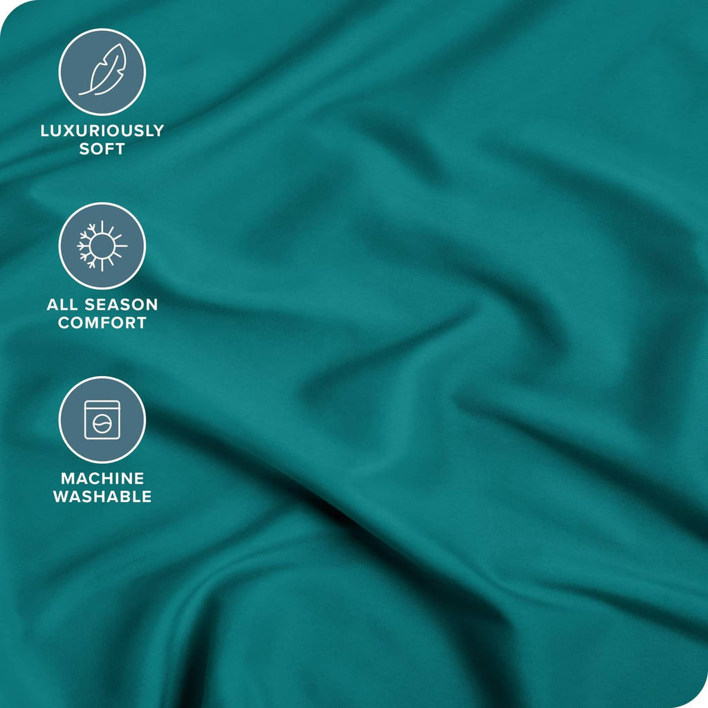 Teal green fitted sheet fabric close-up with wrinkle texture