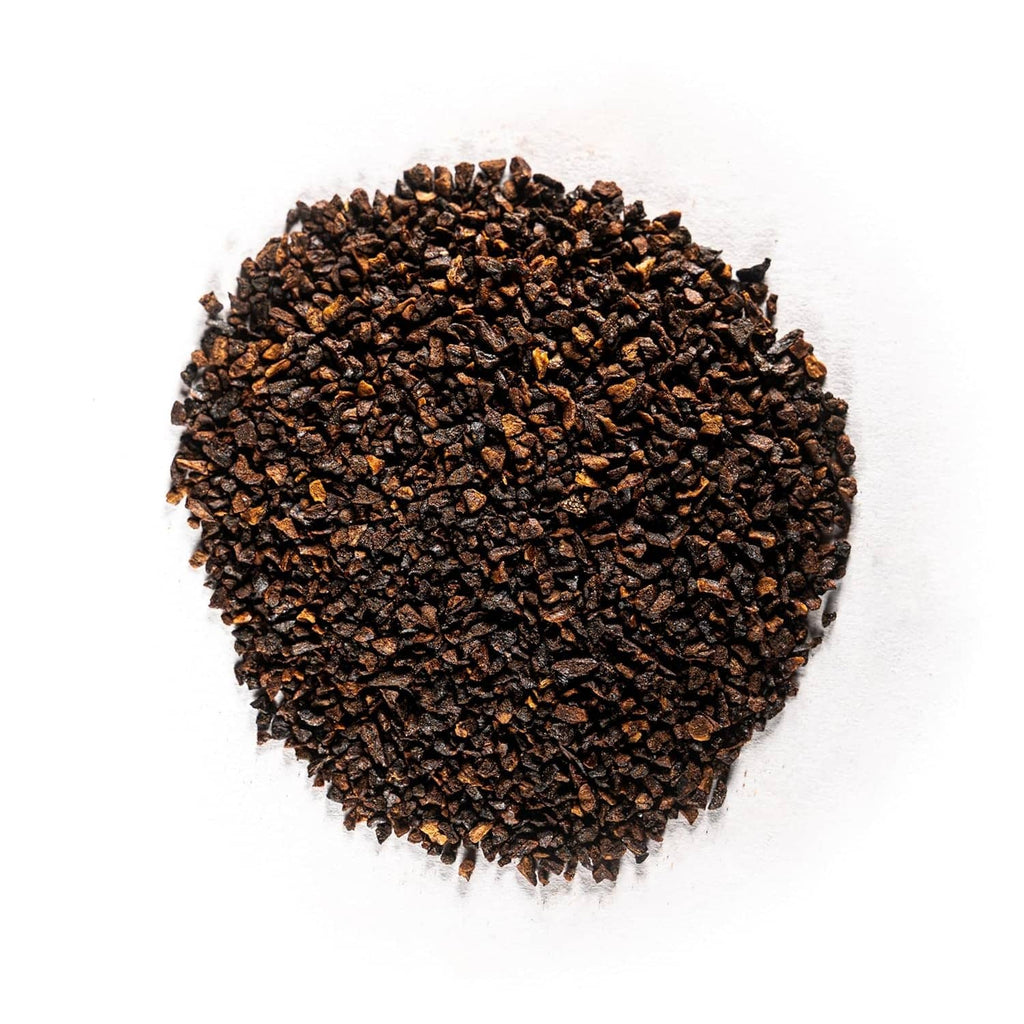 Heap of dark roasted chicory root granules, dry ground