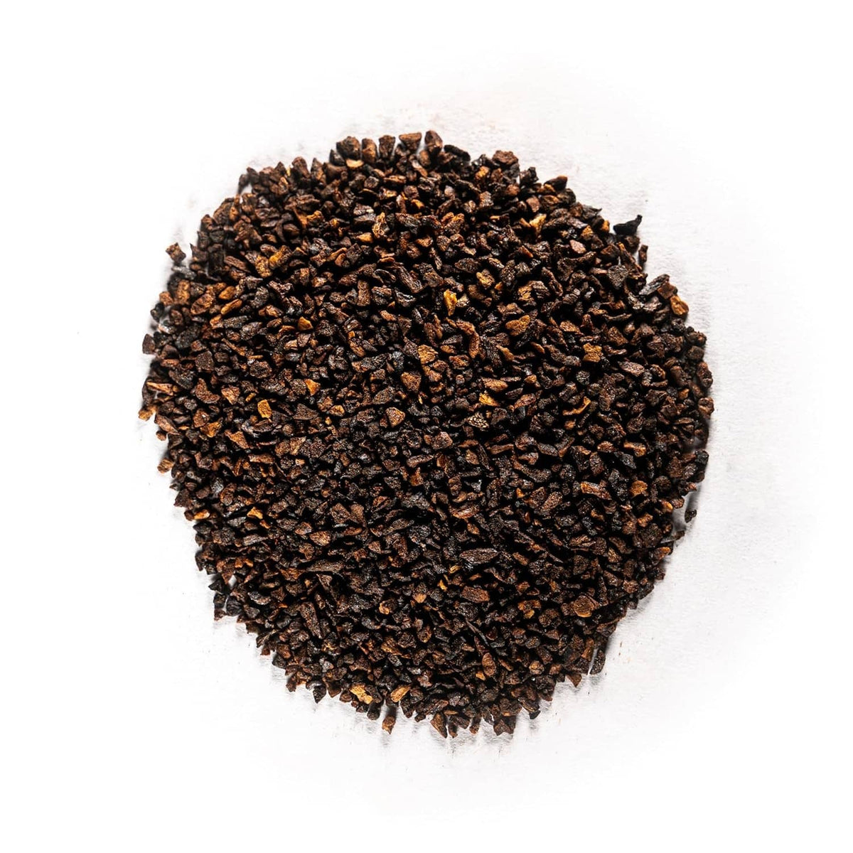 Heap of dark roasted chicory root granules, dry ground