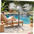 Outdoor misting sprinkler tripod spraying fine mist beside pool patio lounge