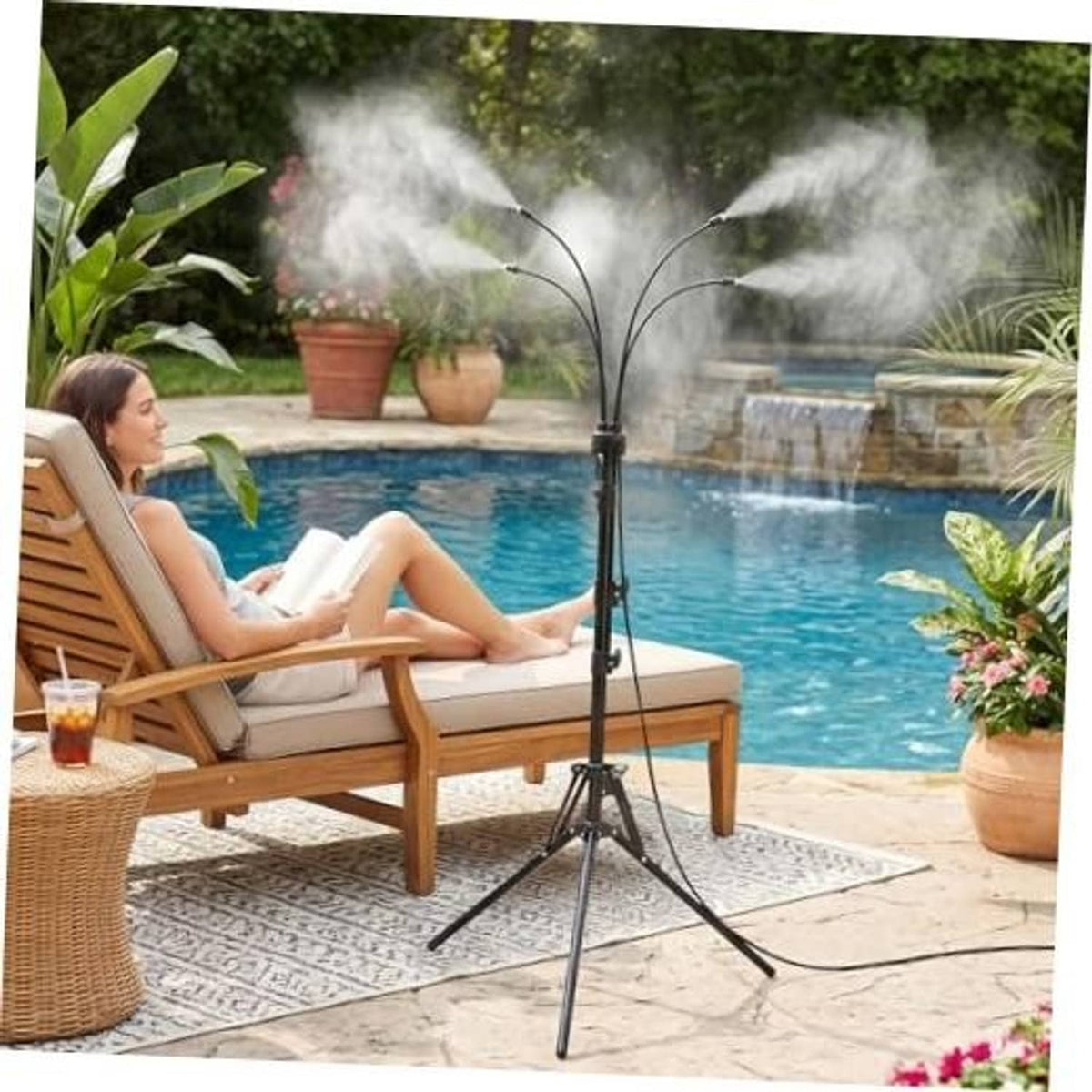 Outdoor misting sprinkler tripod spraying fine mist beside pool patio lounge