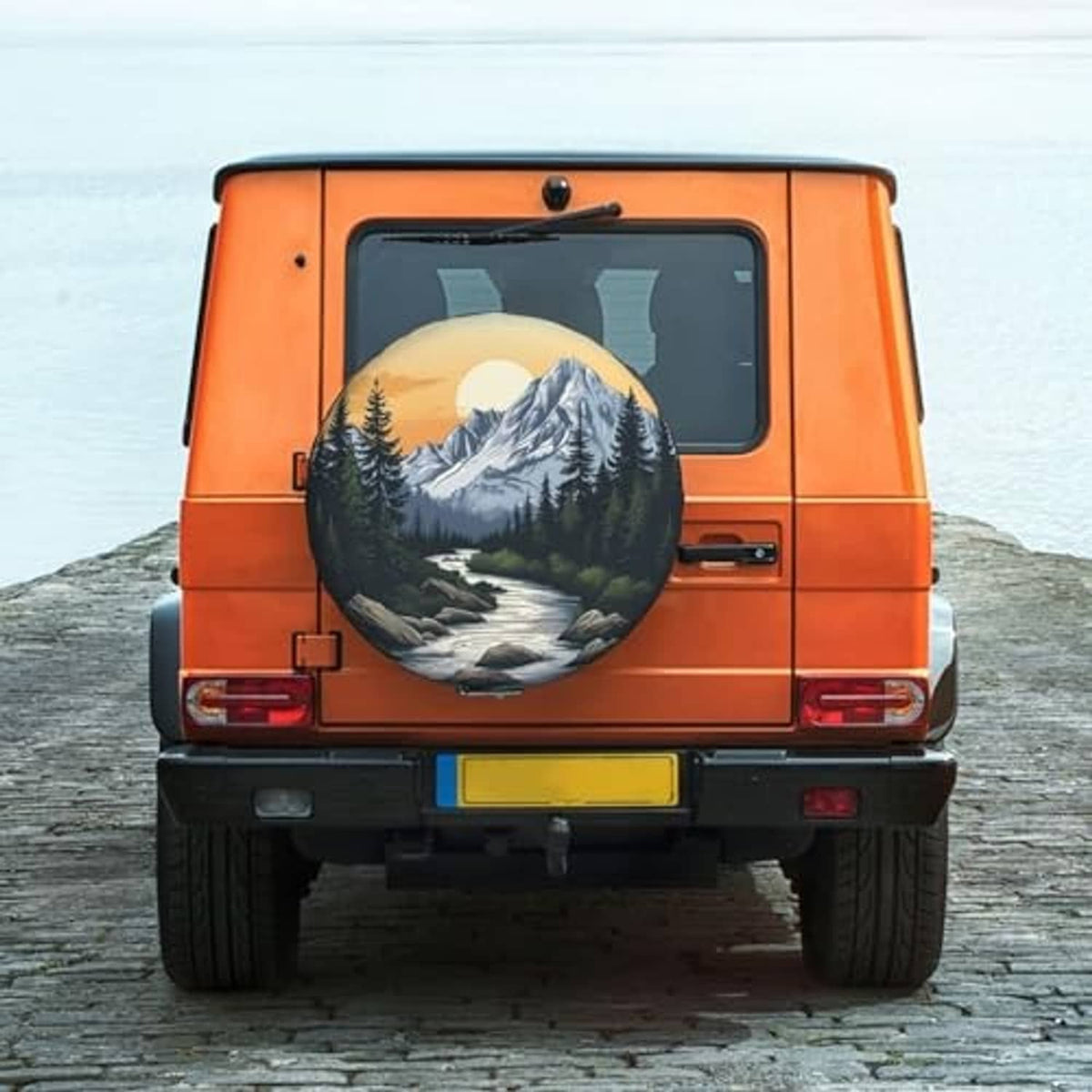 Mountain scenic spare tire cover on rear of orange SUV