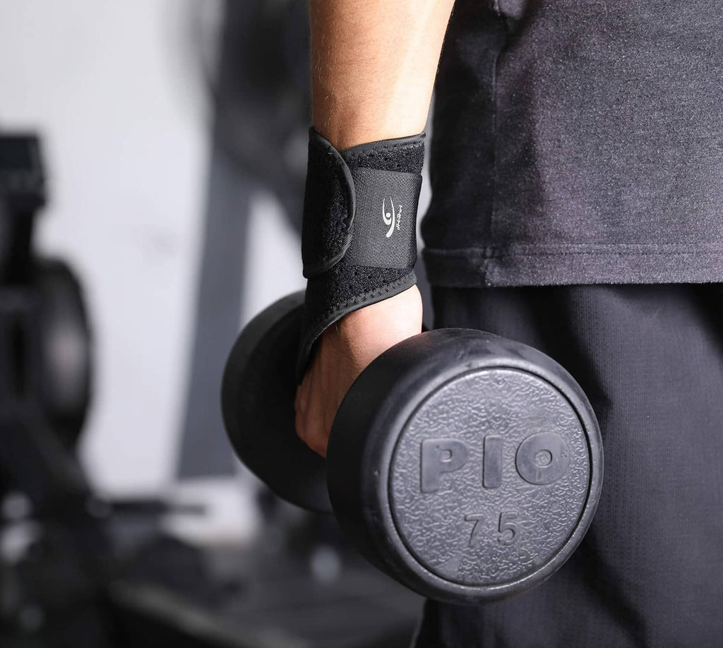 Black wrist compression strap on wrist next to a dumbbell, textured fabric