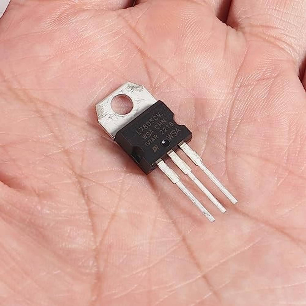 L7805CV 5V regulator IC on palm, metal tab mounting hole, three pin leads