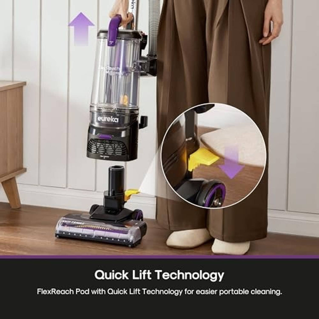 Upright vacuum cleaner with purple dust bin and tool attachments near furniture