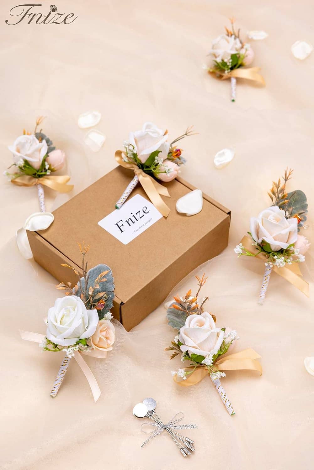 Men's boutonniere set with white roses and greenery, champagne ribbon, shown in gift box