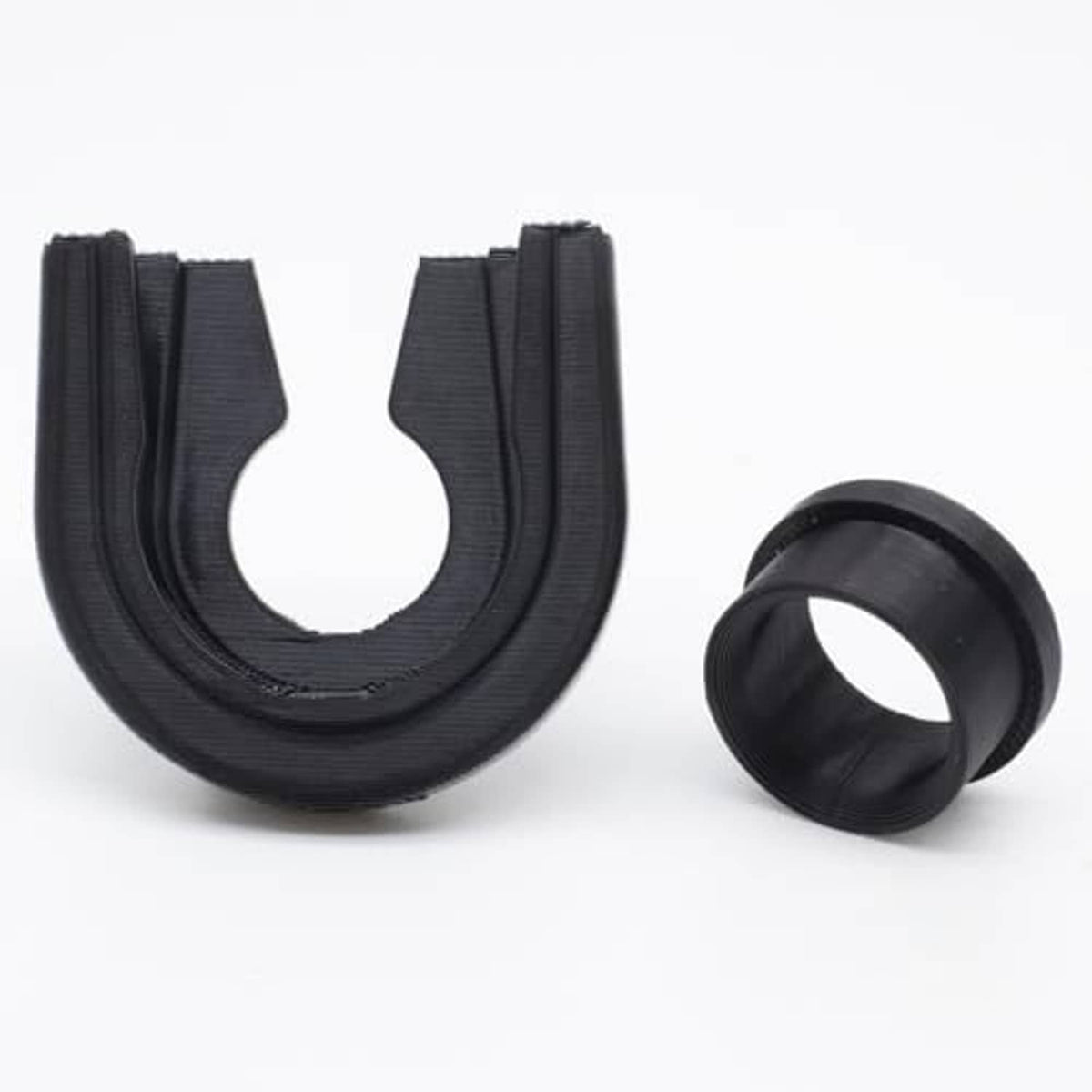 Black U-shaped gearbox repair bushing and matching cylindrical sleeve