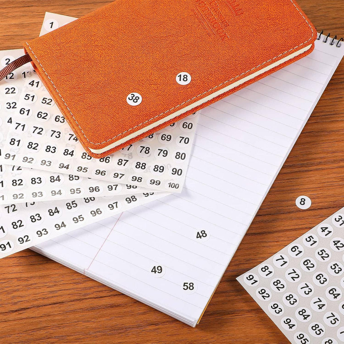 Vinyl consecutive number stickers on a notebook page with scattered numbered dots 1–100