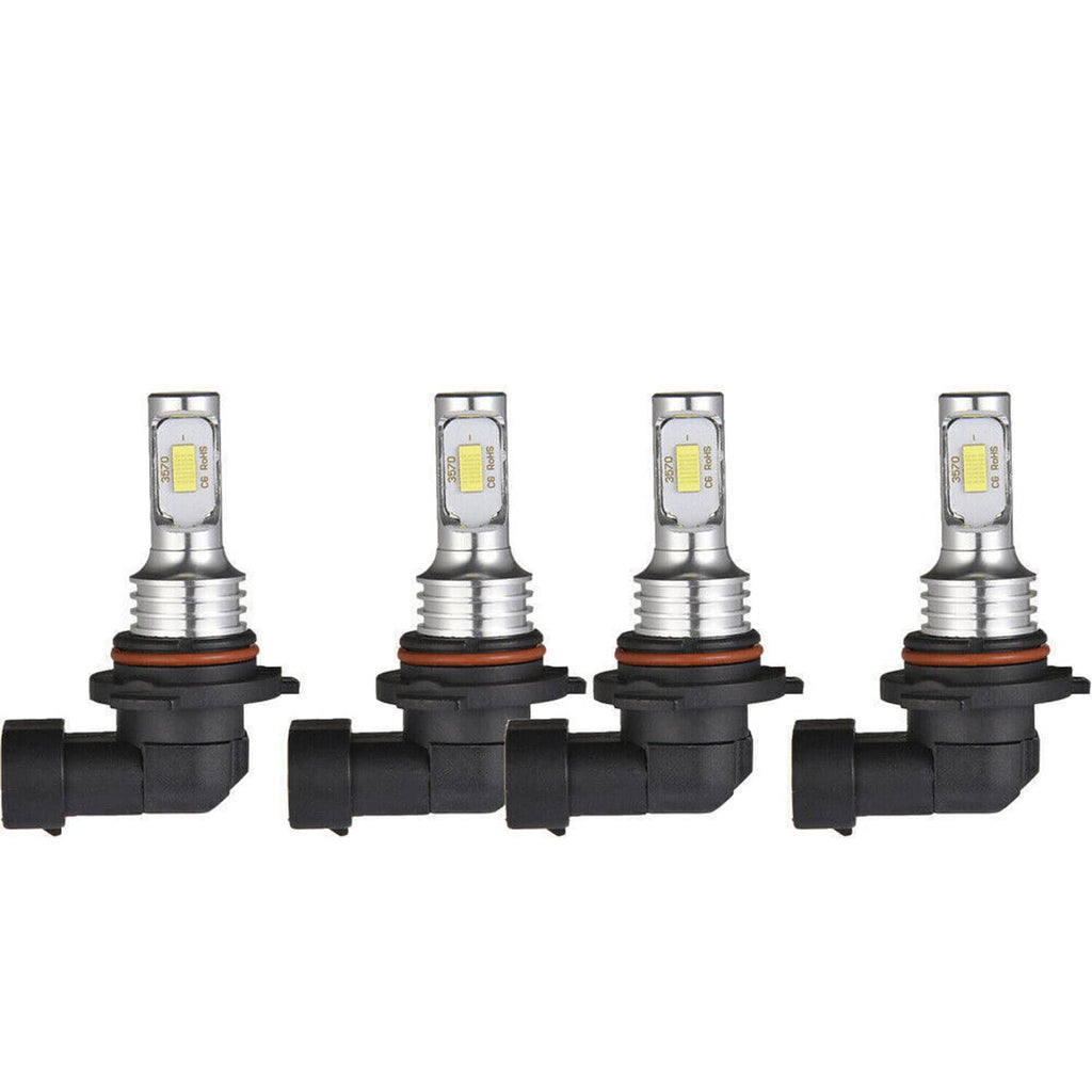 Four LED headlight bulbs with metal heat sinks and black bases, front view