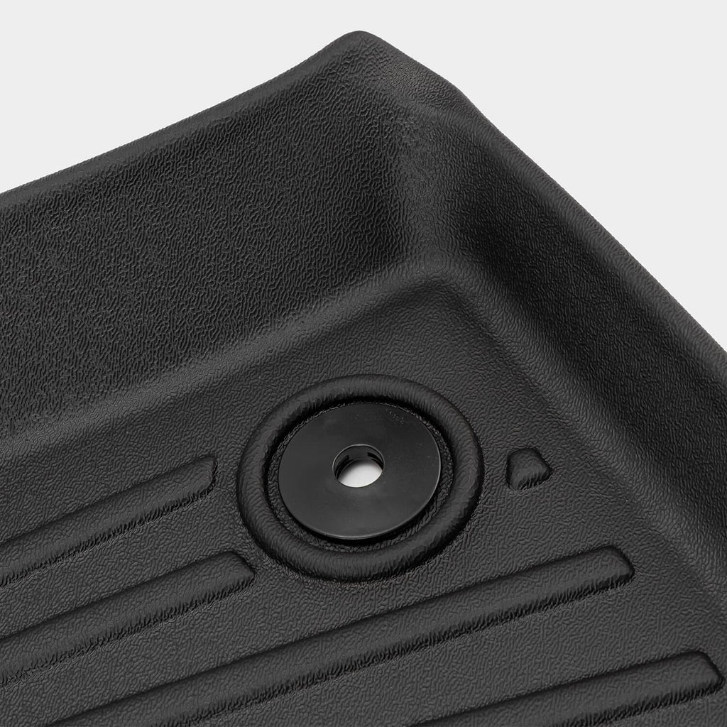 Close-up black rubber mat with circular grommet and raised tread ribs