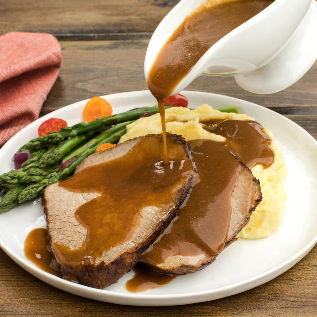Sliced roast with brown gravy on a white plate