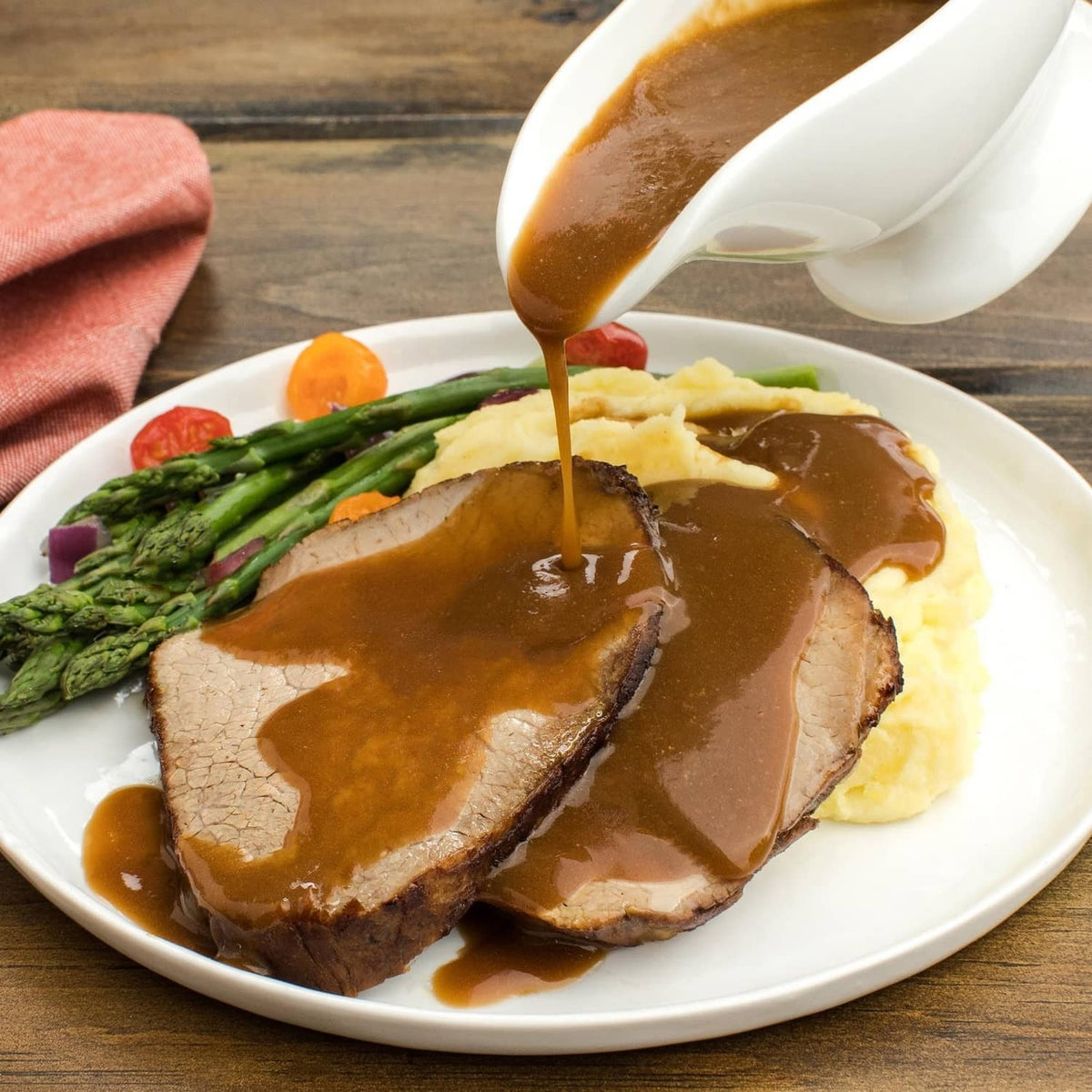 Sliced roast with brown gravy on a white plate