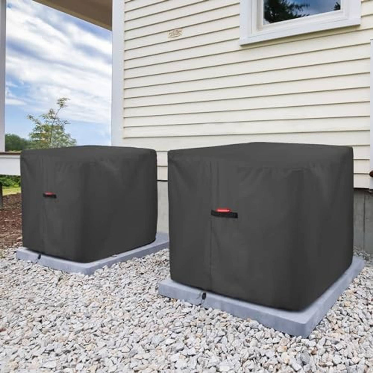 Two square dark AC covers with top vent panels on outdoor gravel