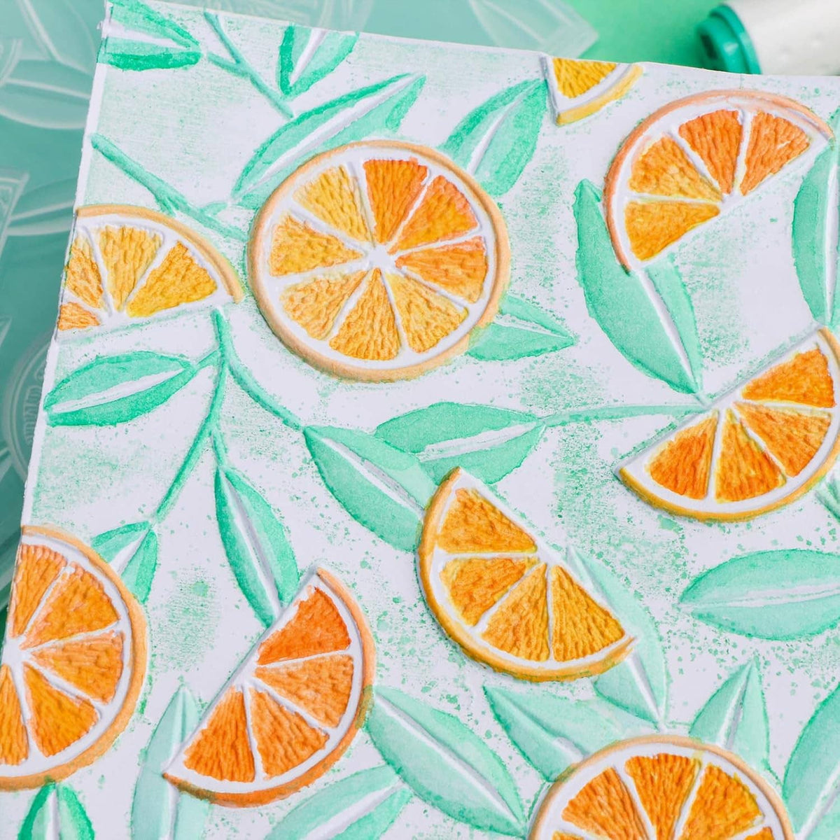 Close-up embossed lemon slice and leaf pattern on light paper