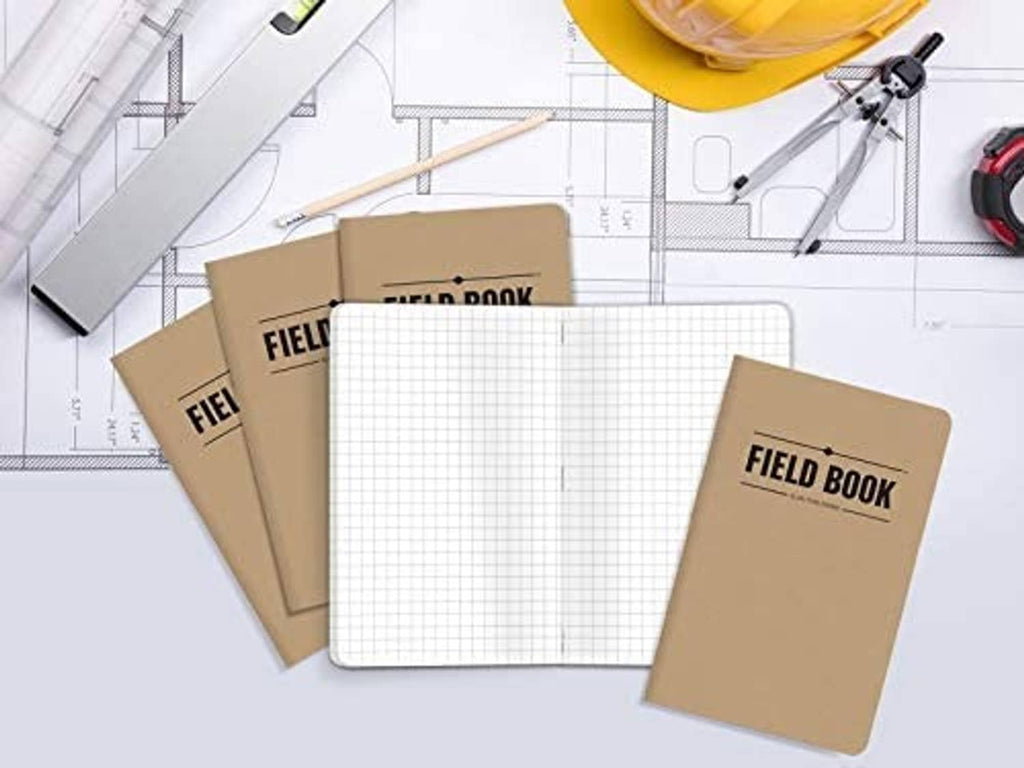 Five kraft pocket notebooks with 'FIELD BOOK' covers on a blueprint with grid paper