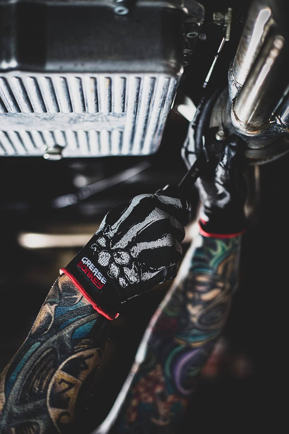 Close-up mechanic glove, black with white bone grip print, red knit cuff