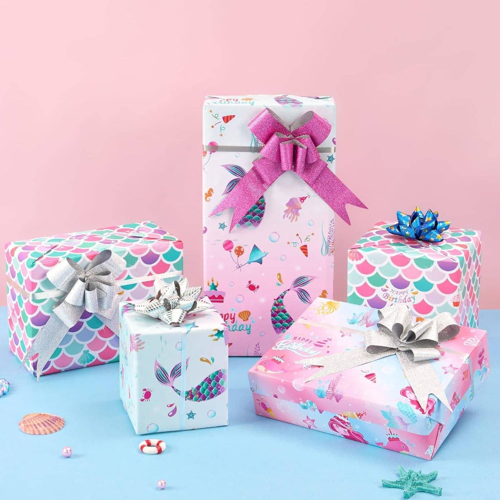 Set of birthday gifts wrapped in mermaid-scale and ocean-themed wrapping paper