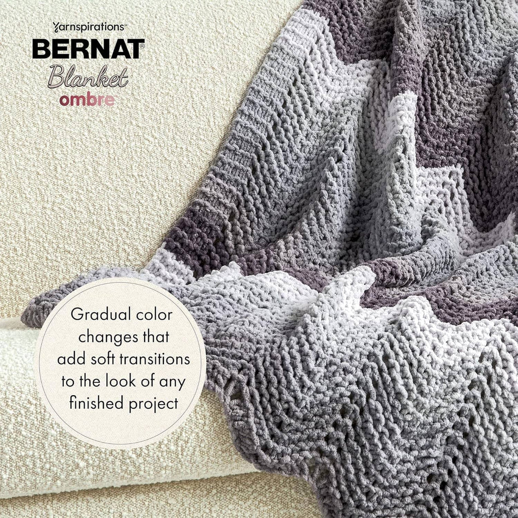 Chunky knit blanket with gray ombre color fade, textured cable-like stitch pattern