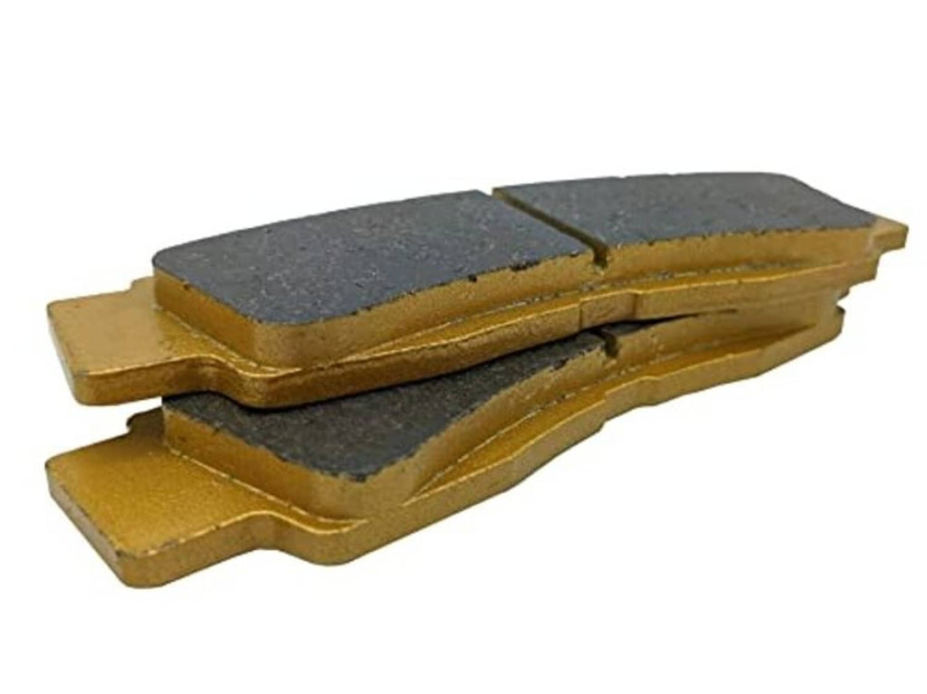 Close-up of ceramic brake pads: dark friction faces on gold backing