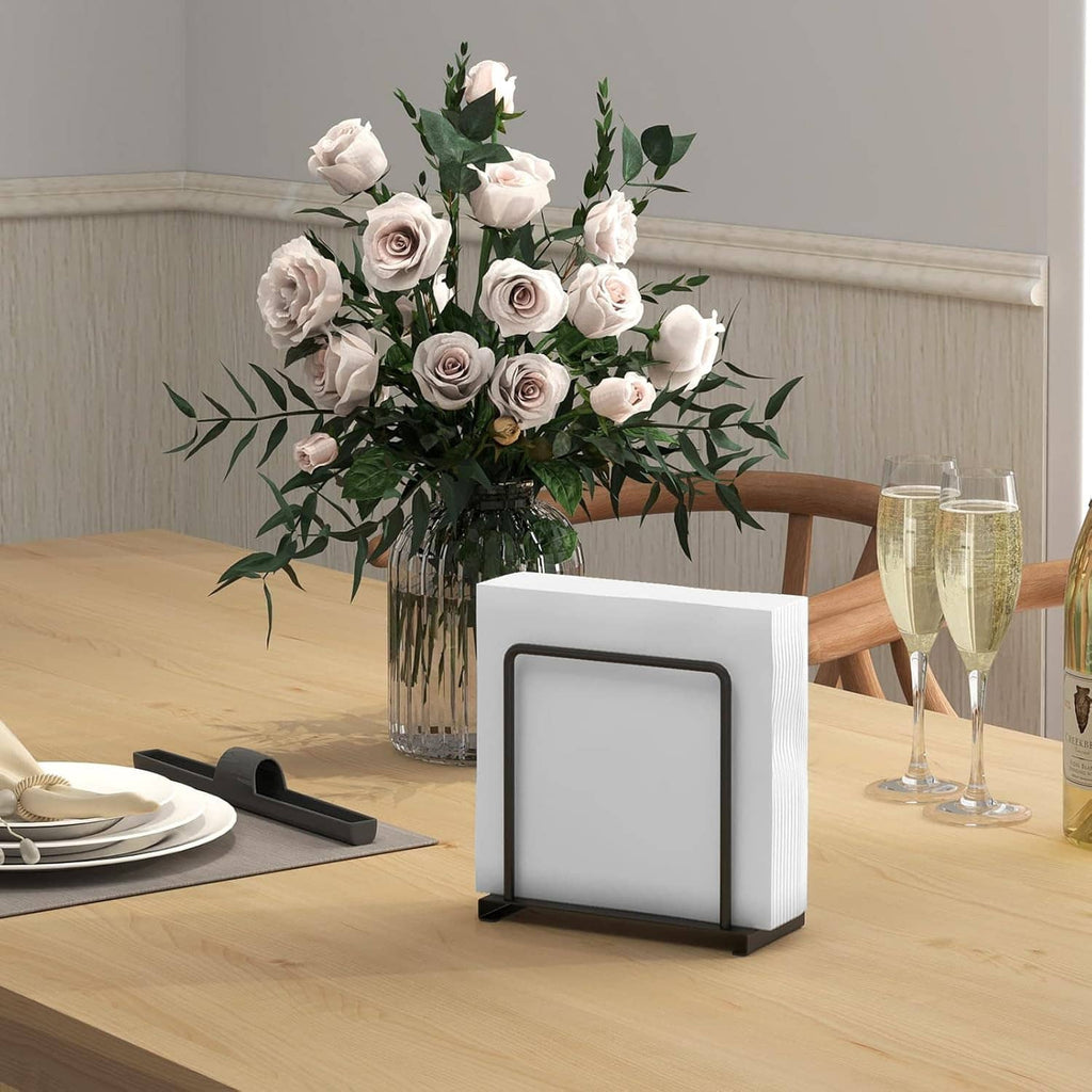 White standing napkin holder with black metal frame and non-slip base on a tabletop