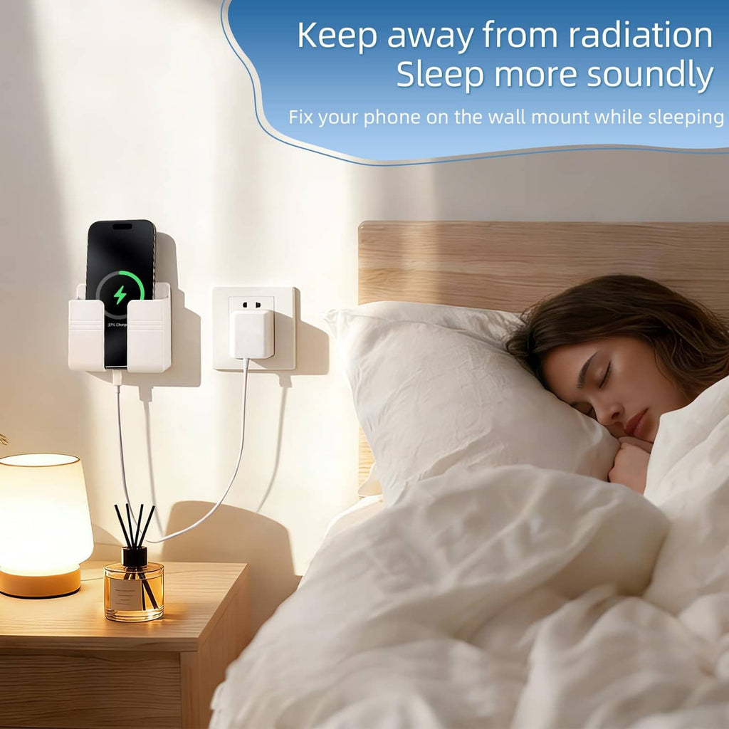 White wall phone holder mounted beside a bed with charging cables connected
