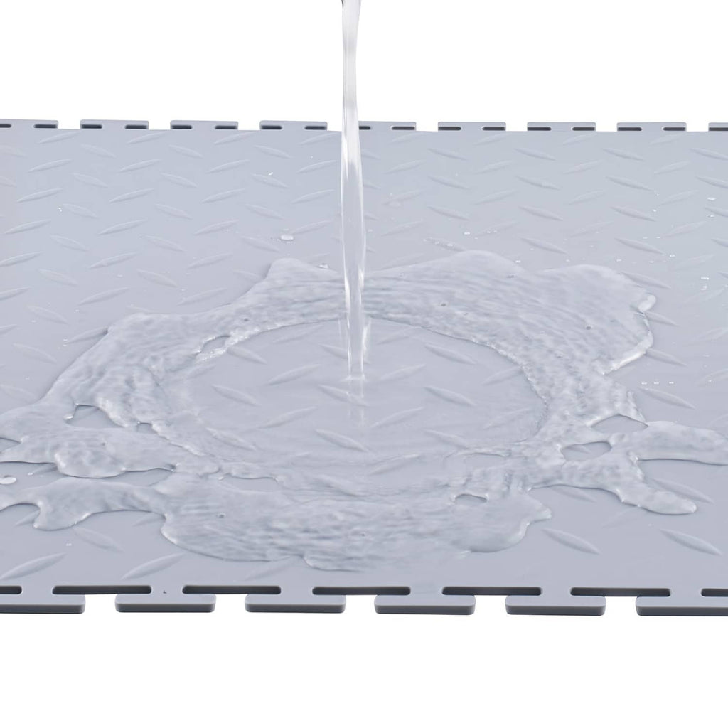Silver PVC garage floor tile with diamond plate texture; water pooling on surface