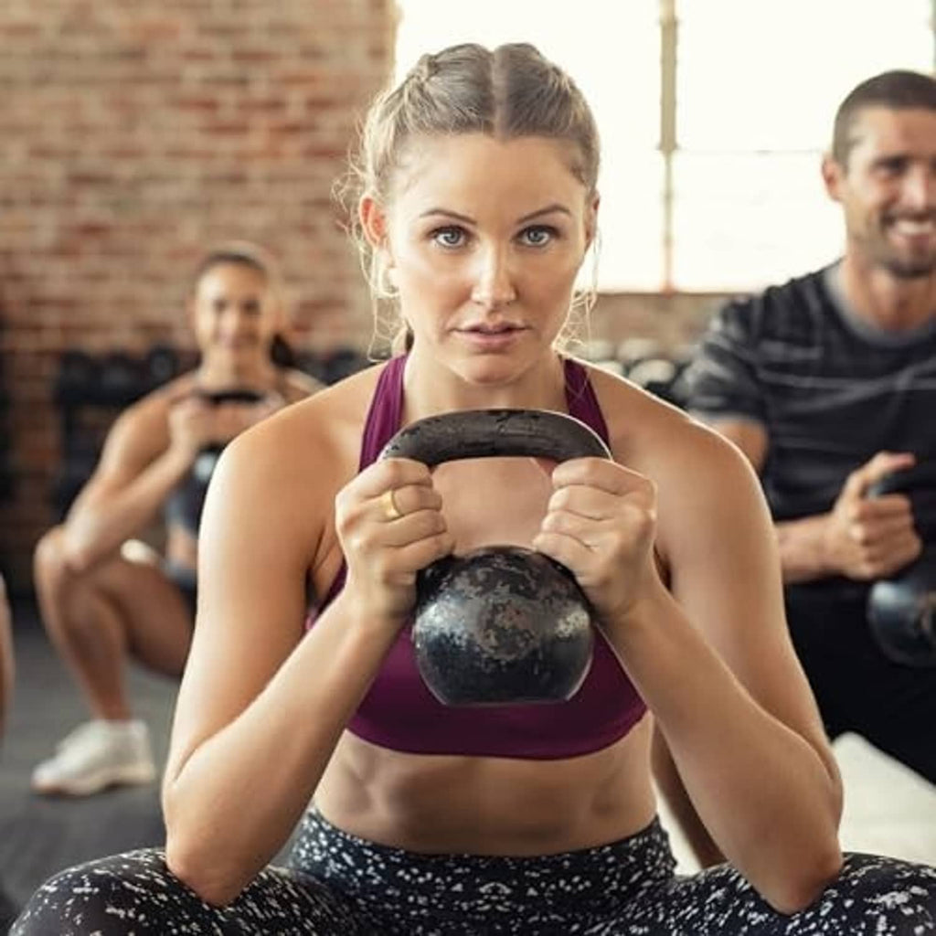 Workout lifestyle scene with a woman holding a kettlebell; silicone ring protector not visible