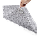 Pebble bath tub shower mat, gray textured grip surface held by hand