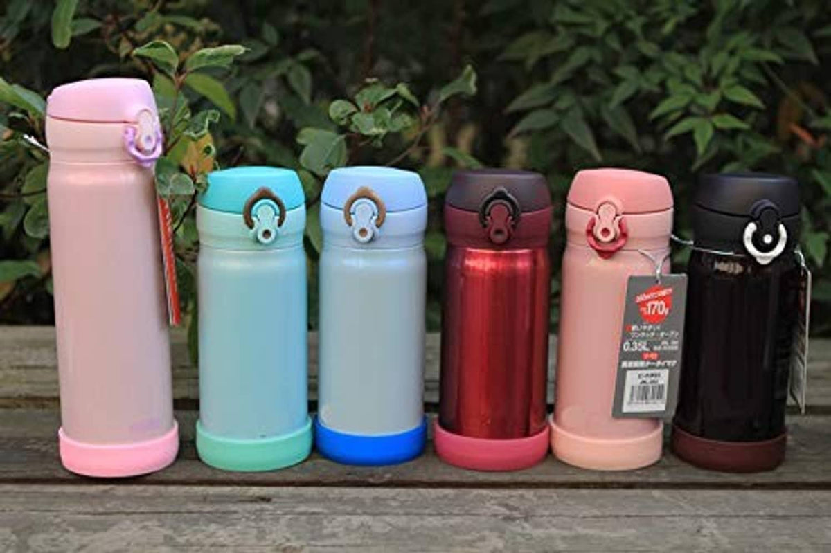 Assorted silicone bottle base protective sleeves on standing bottles in outdoor setting