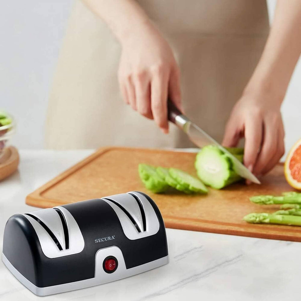 Secura 2-stage knife sharpener on countertop while hands slice vegetables on a cutting board
