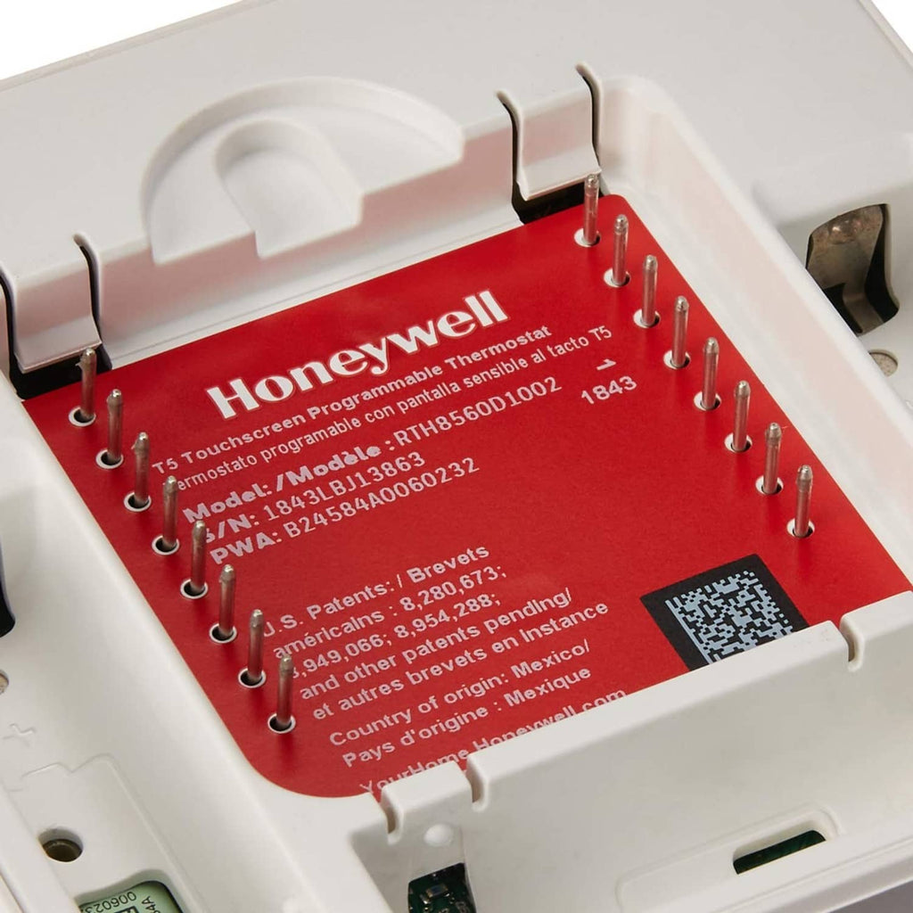 Honeywell thermostat mounting module with red label, terminal pins, and wiring holes
