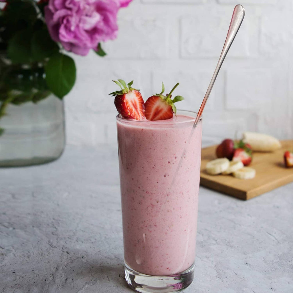 Long stainless mixing spoon in a tall strawberry smoothie glass, oval bowl