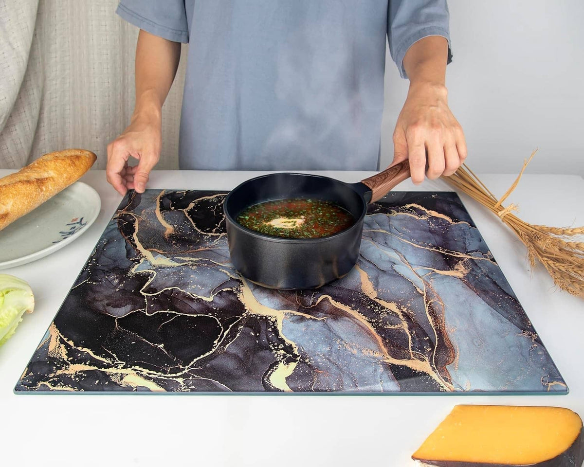 Tempered glass cutting board with marbled pattern, pot and sliced bread placed on top