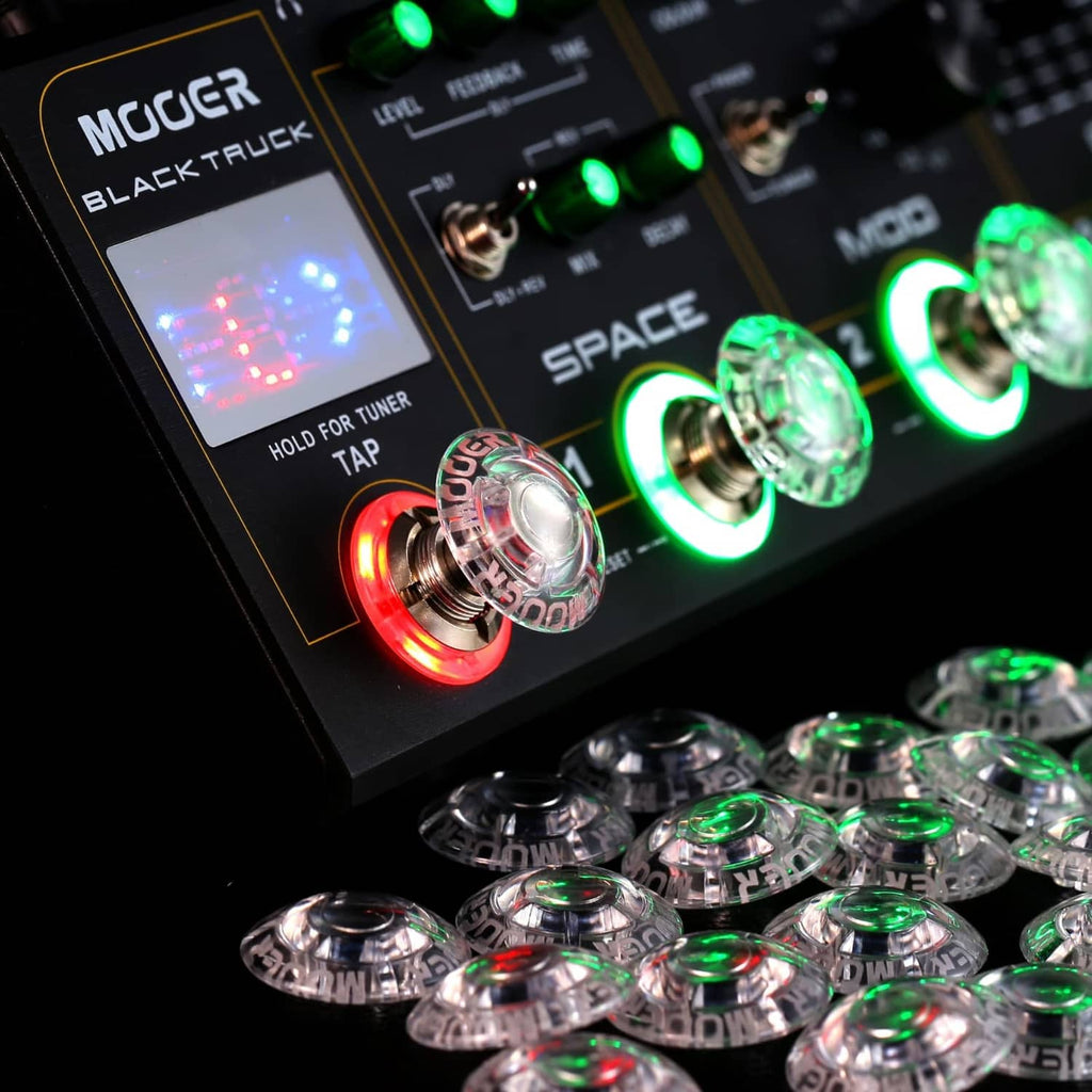 Clear mushroom-shaped footswitch toppers on guitar pedals with green and red LEDs