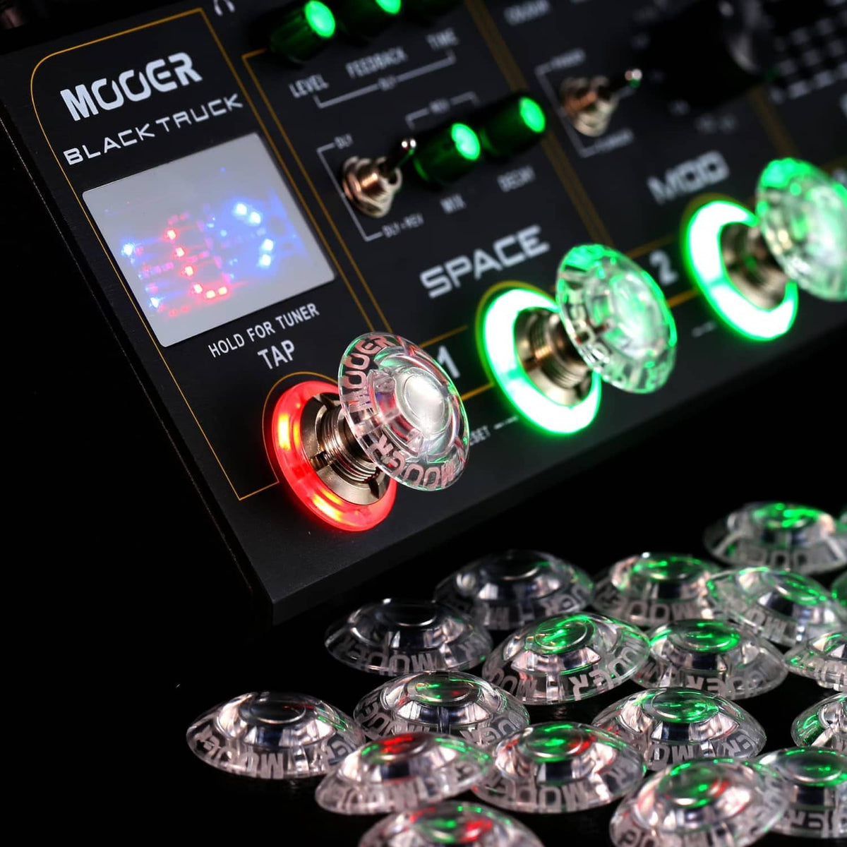 Clear mushroom-shaped footswitch toppers on guitar pedals with green and red LEDs