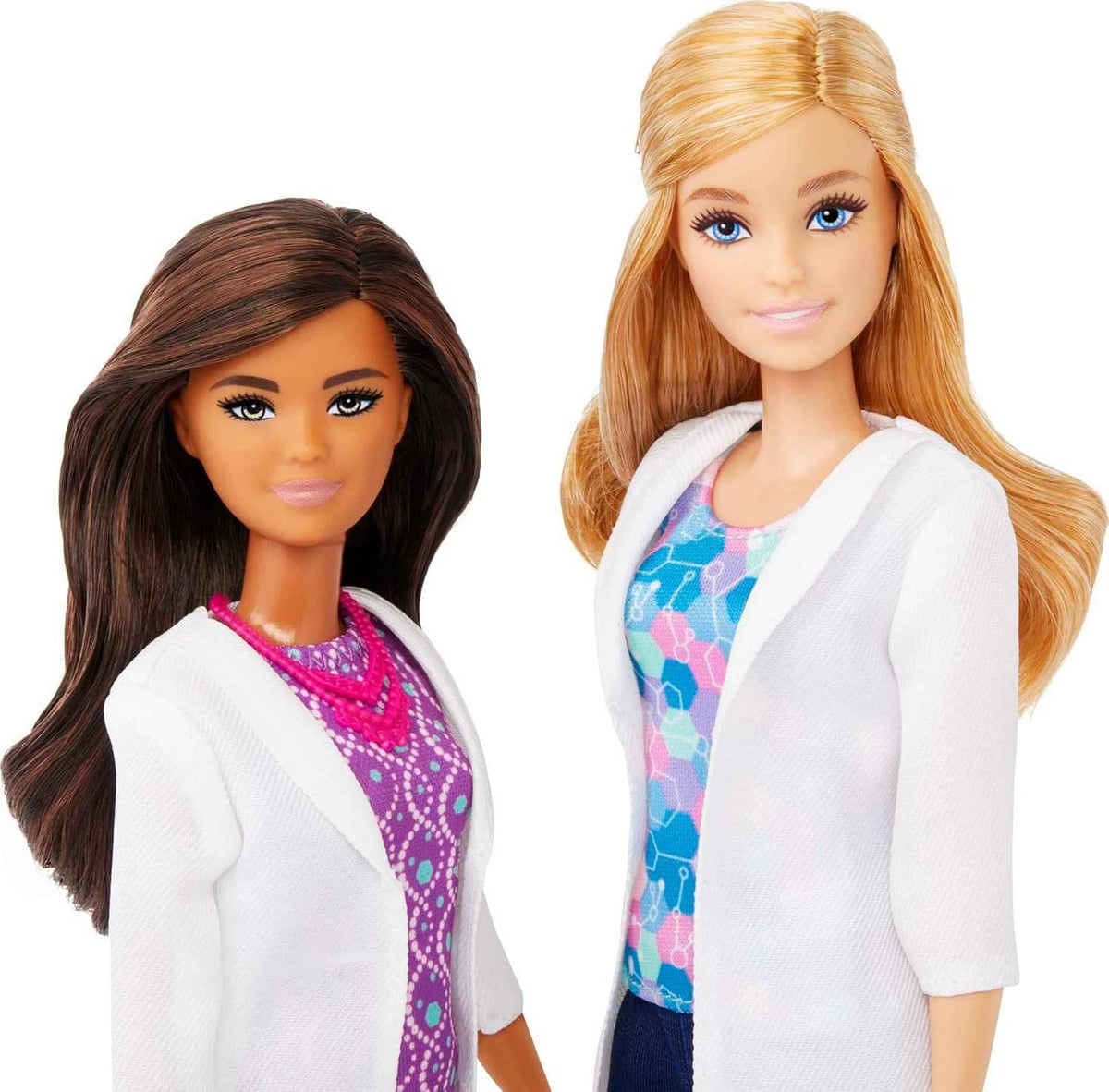 Science fashion dolls close-up: dark-haired doll in purple dress, blonde doll in lab coat