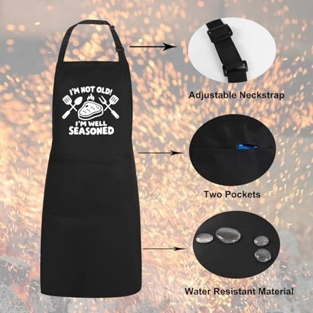 Black adjustable-neck apron with two pockets, water-resistant fabric, and "well seasoned" graphic