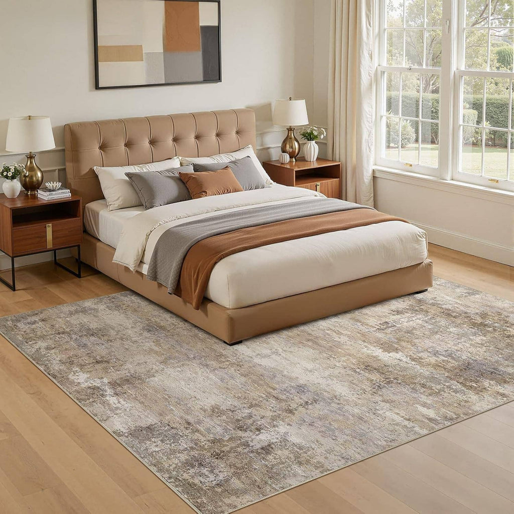Distressed beige and gray area rug with bordered edge in bedroom setting