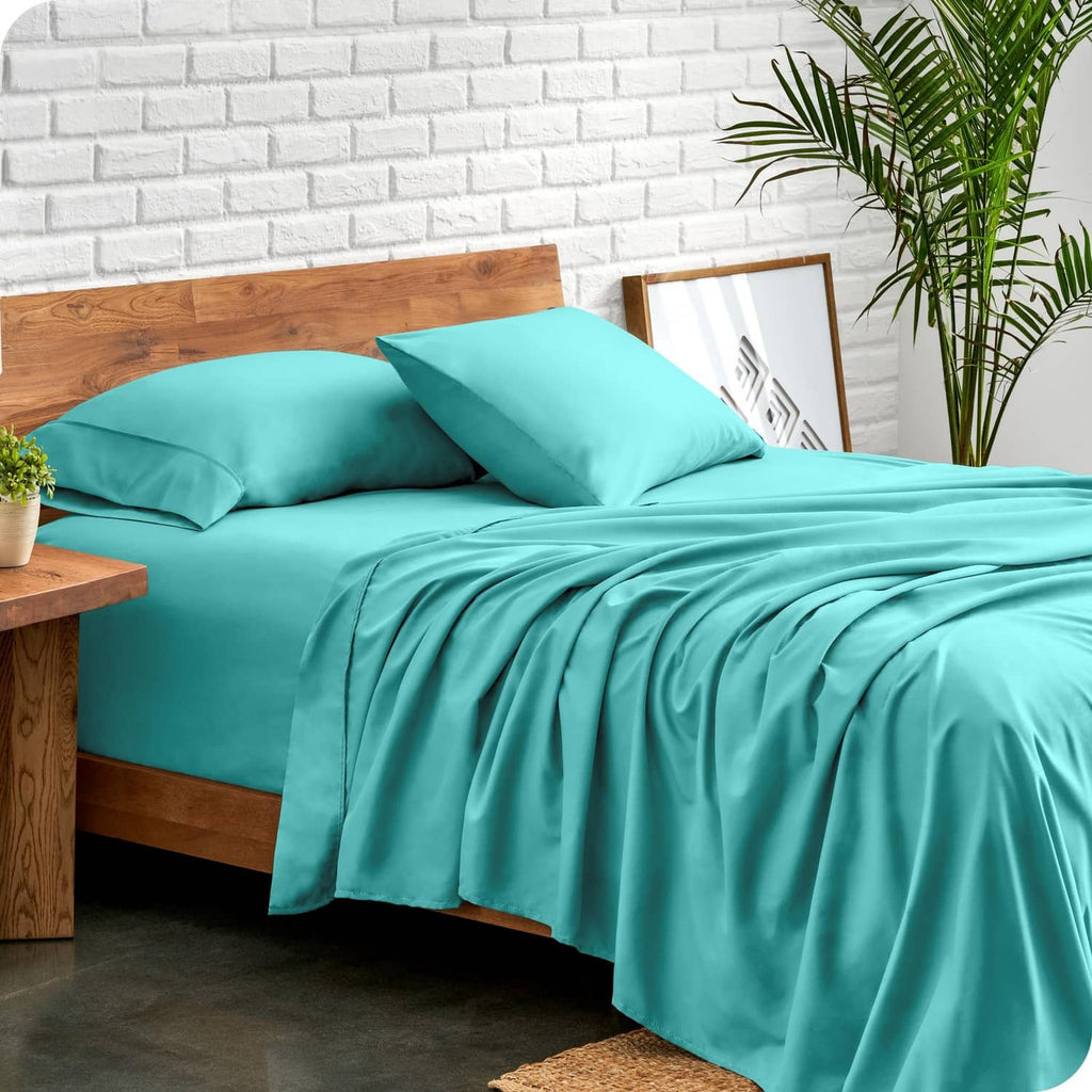 Turquoise twin bed sheet set with pillows and draped flat sheet across the bed