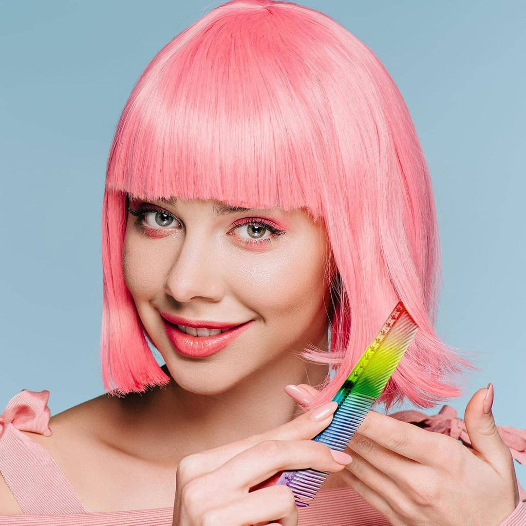 Rainbow rat tail hair comb with fine teeth held near pink hair fringe