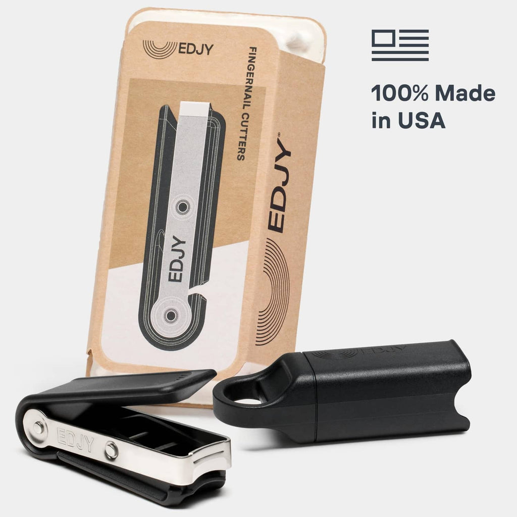 Black fingernail clipper with silver blade and cap, shown with retail box